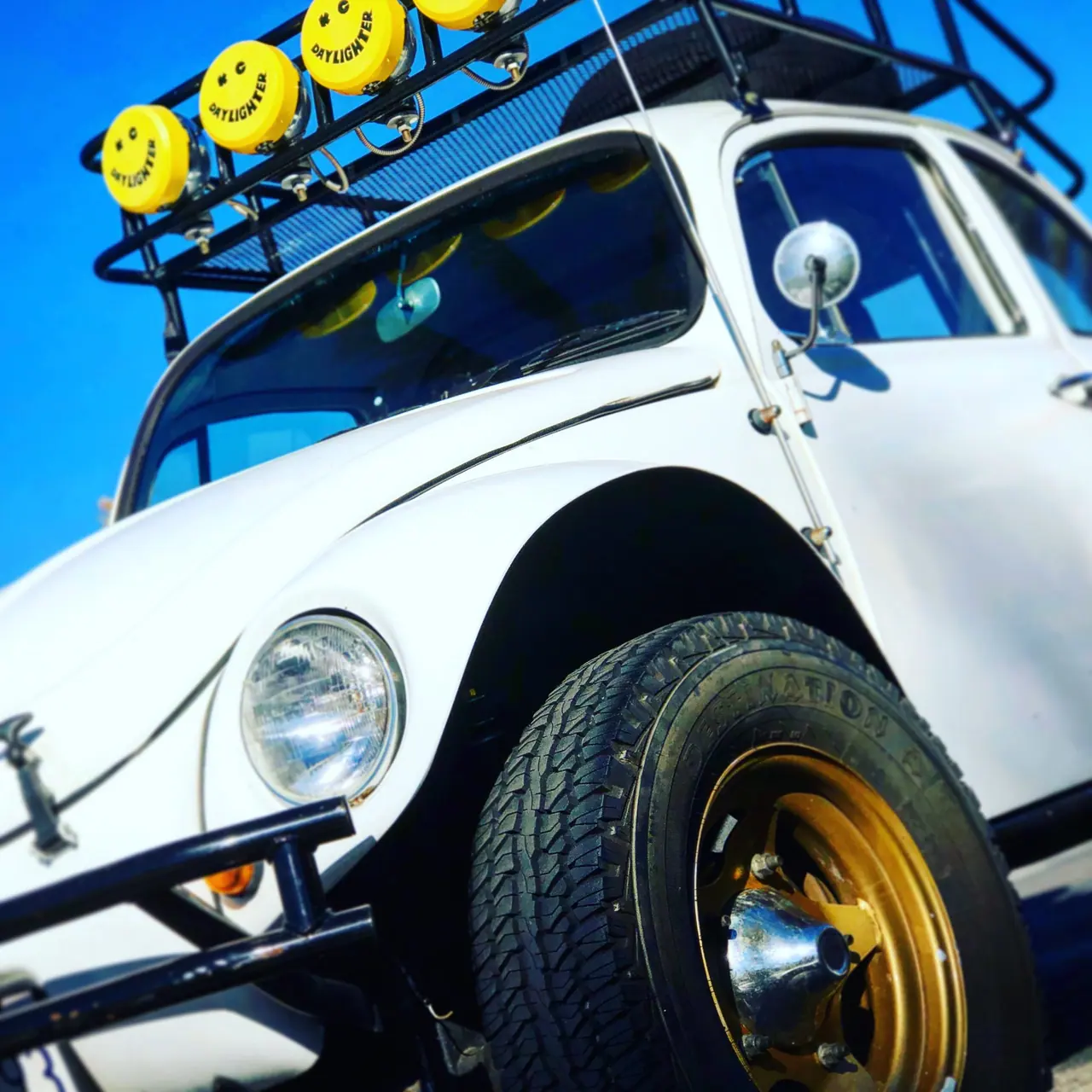 A modified Volkswagen Beetle with yellow roof lights.