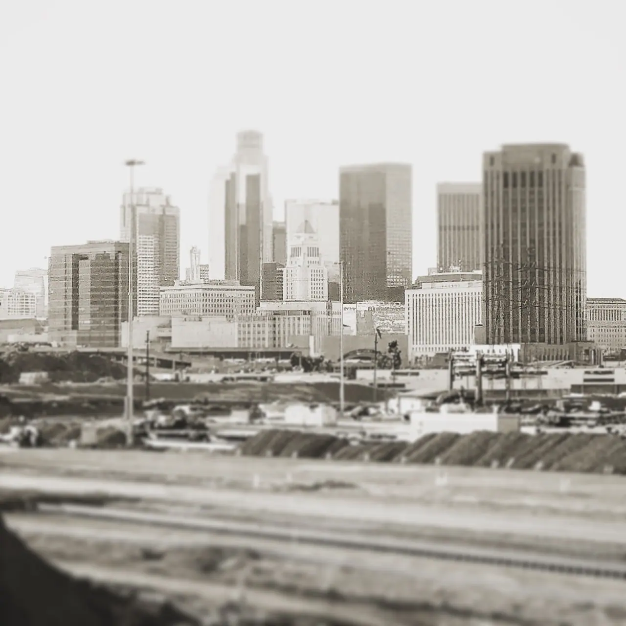 The downtown Los Angeles skyline beyond the freeway, in monochrome.
