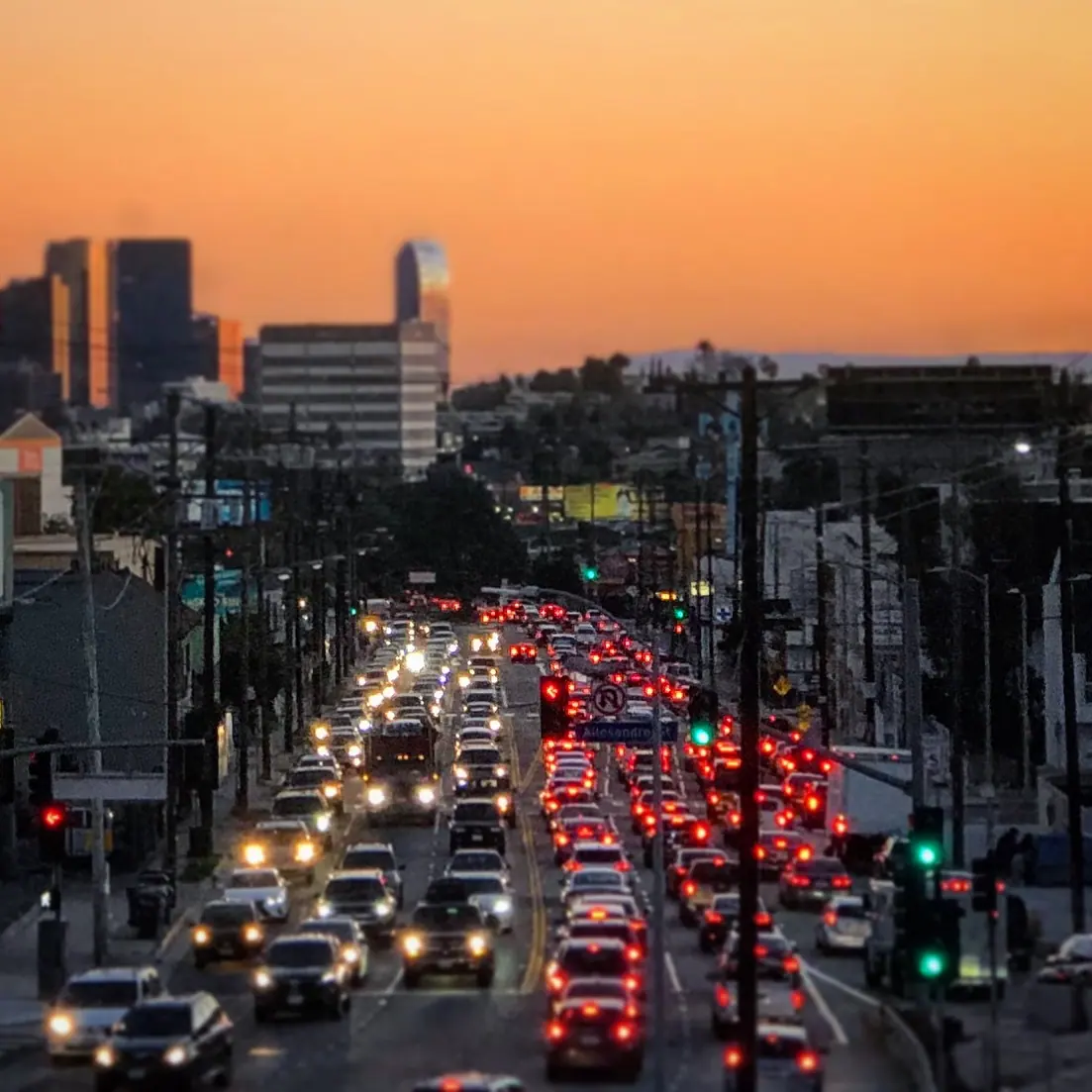 Evening traffic beneath an orange Los Angeles sky.