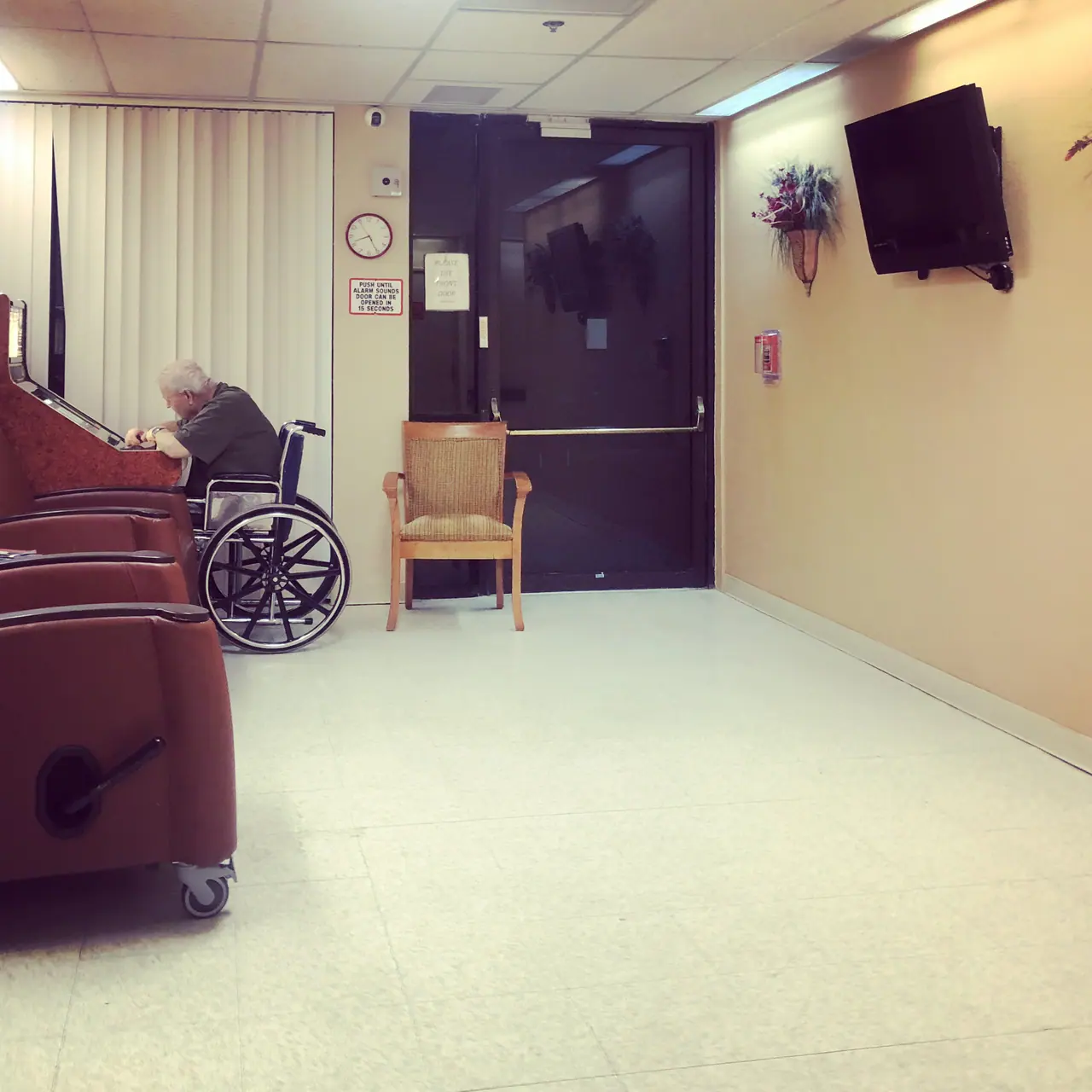 A quiet waiting room with a seated visitor.