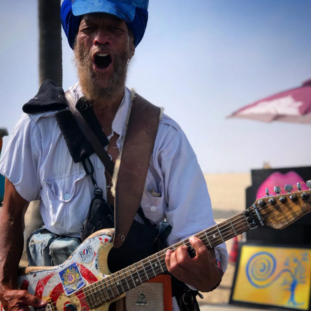 A street guitarist performing at Venice Beach.