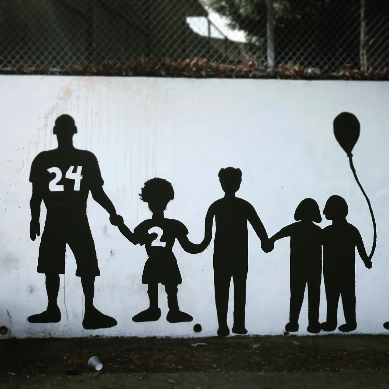 A silhouette mural of an adult and children holding hands.