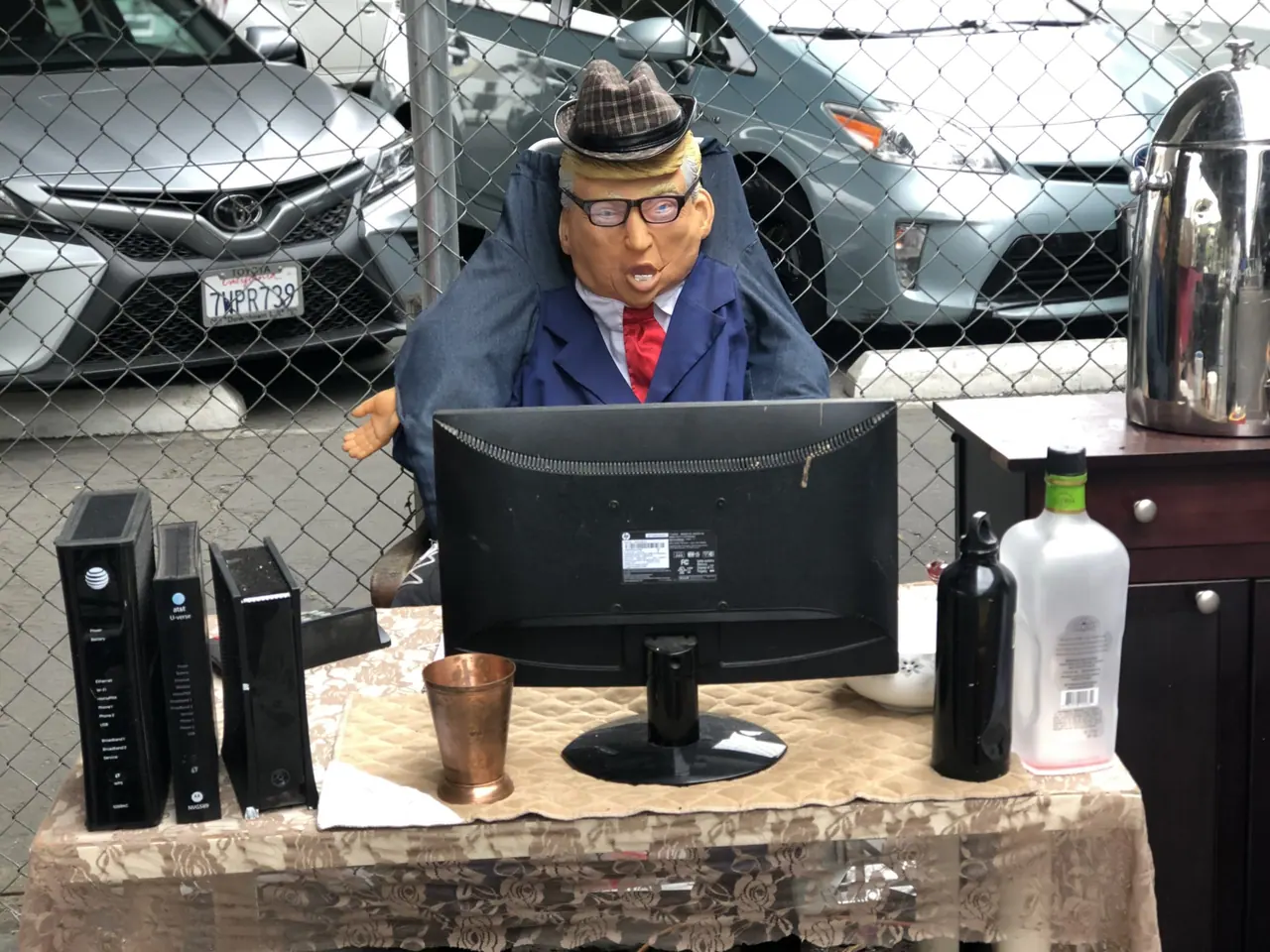 A mannequin seated at an outdoor computer desk.