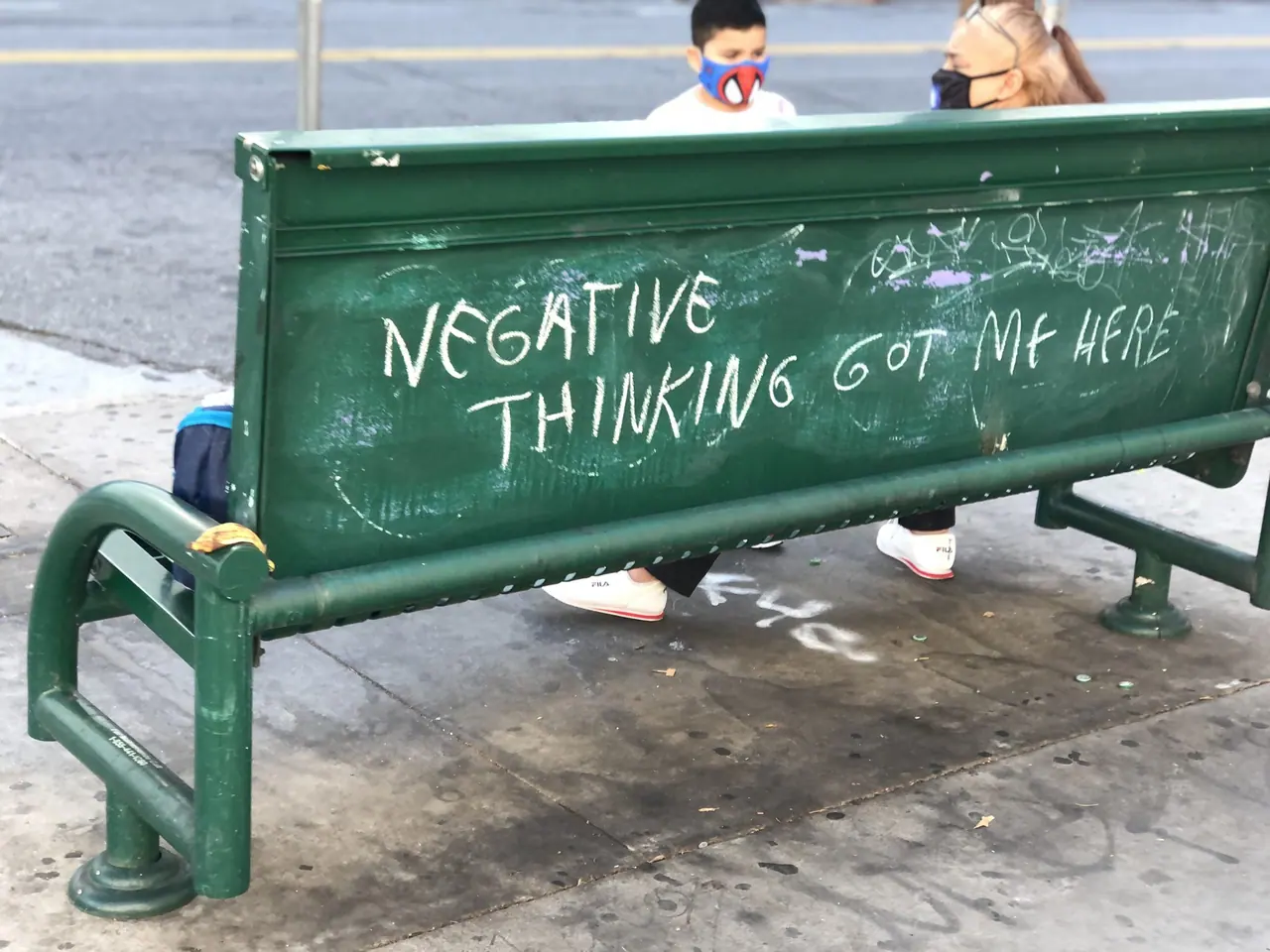 A message written across a green park bench.
