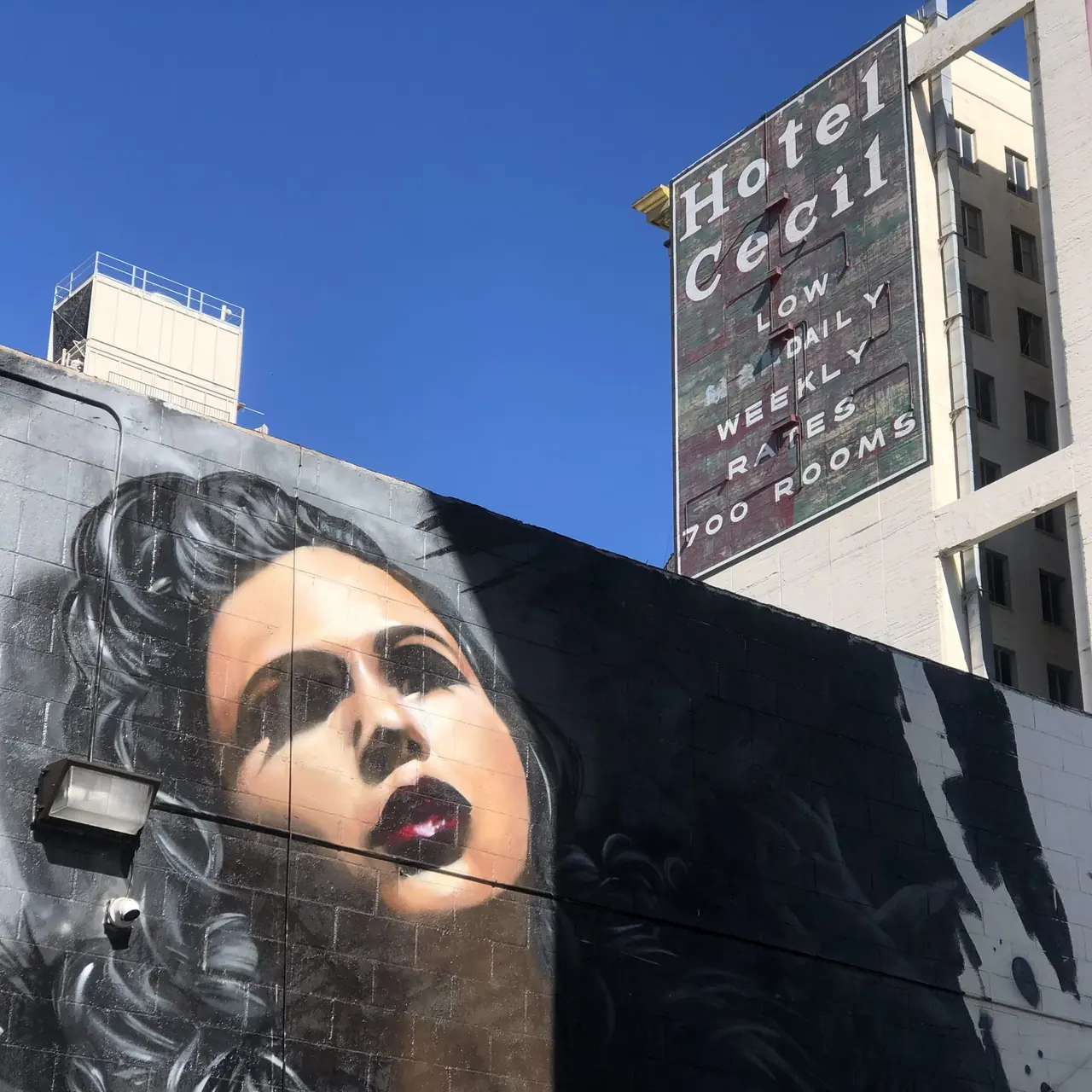 A portrait mural beneath the Hotel Cecil sign.
