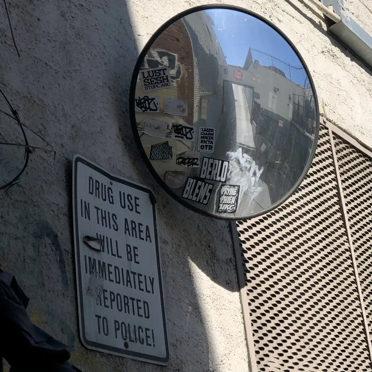 An alley reflected in a convex security mirror.