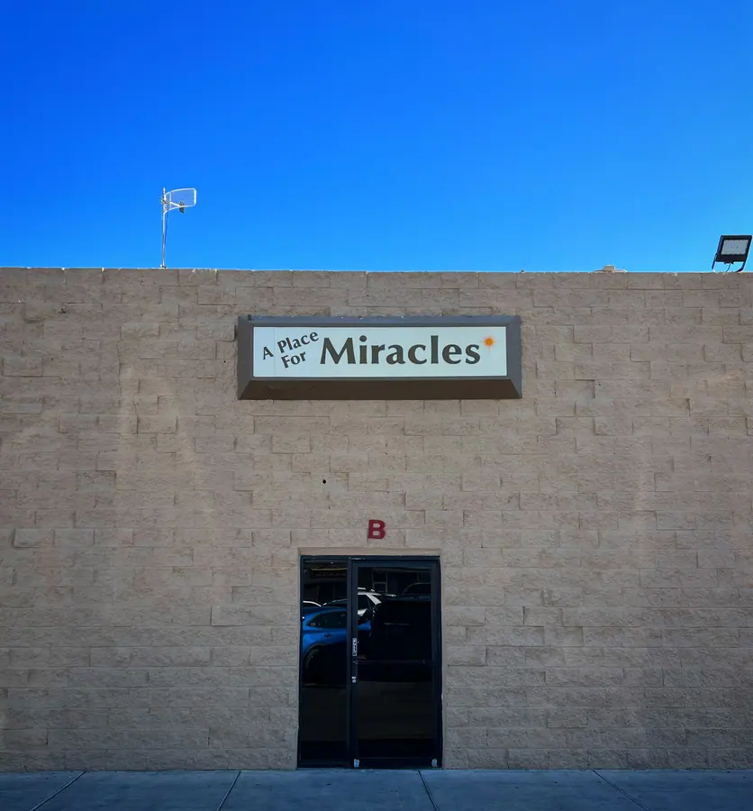 A small doorway beneath a sign promising miracles.
