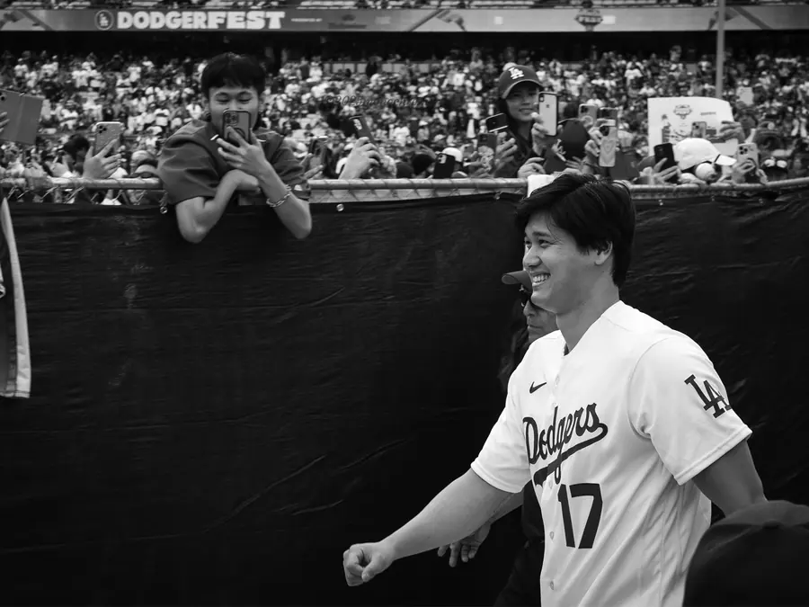 A Dodgers player walking past spectators at a stadium fan event.