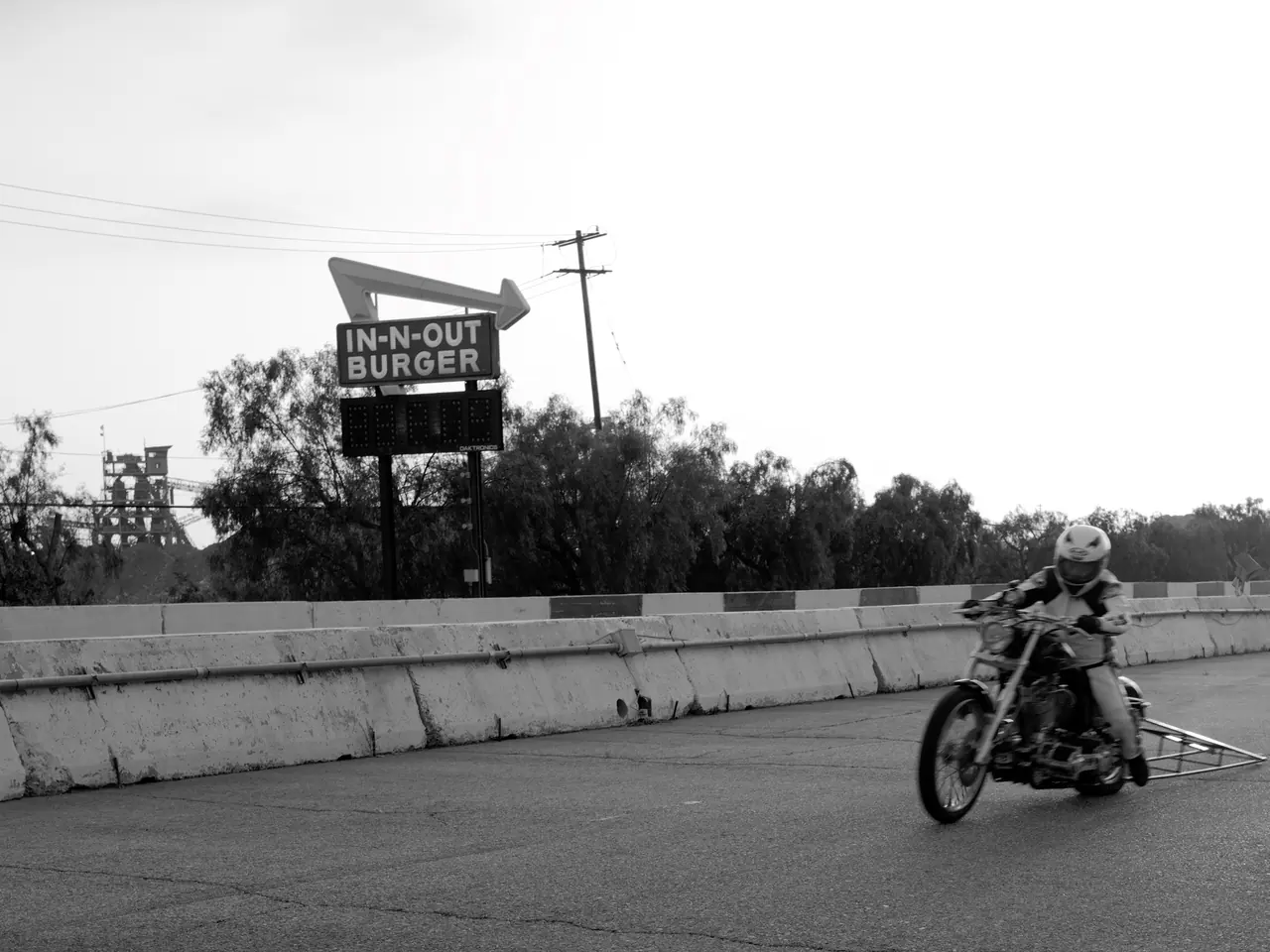 A rider crossing the pavement near an In-N-Out Burger sign at Irwindale.
