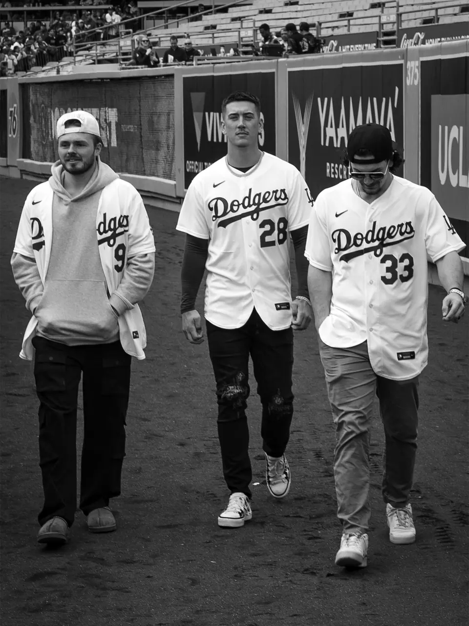 Three baseball players walking together on the field.