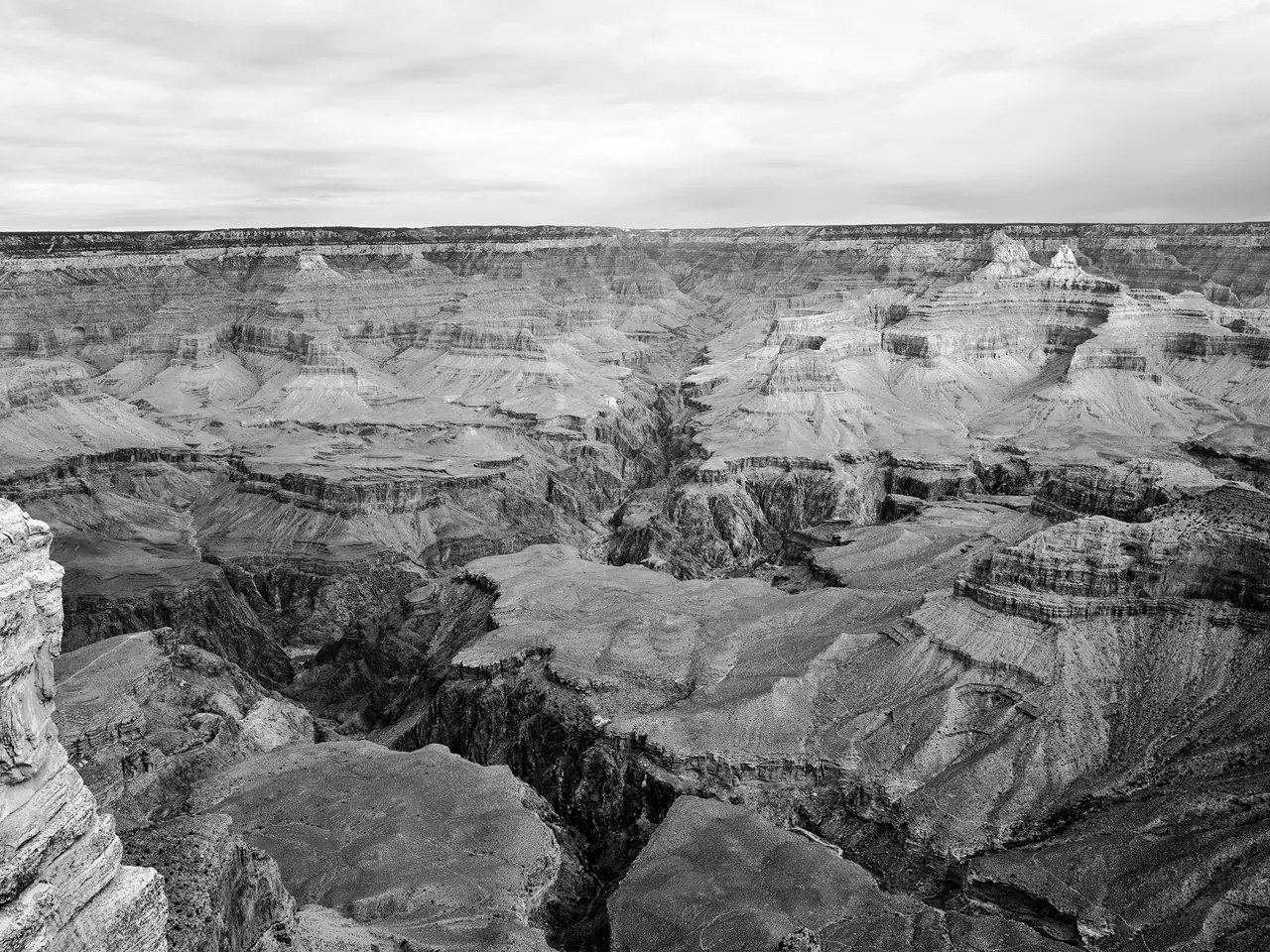 Layered cliffs and deep ravines at the Grand Canyon, in monochrome.