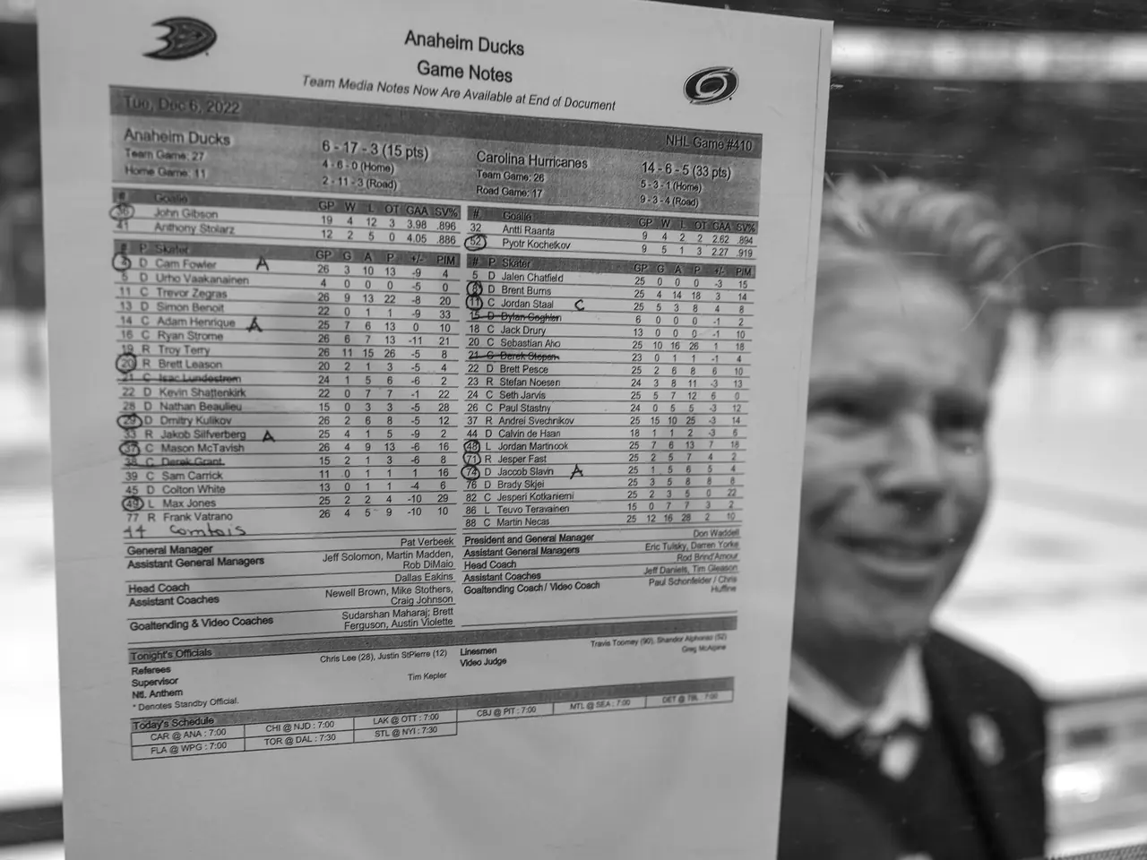 A hockey game-notes sheet held in front of the rink.