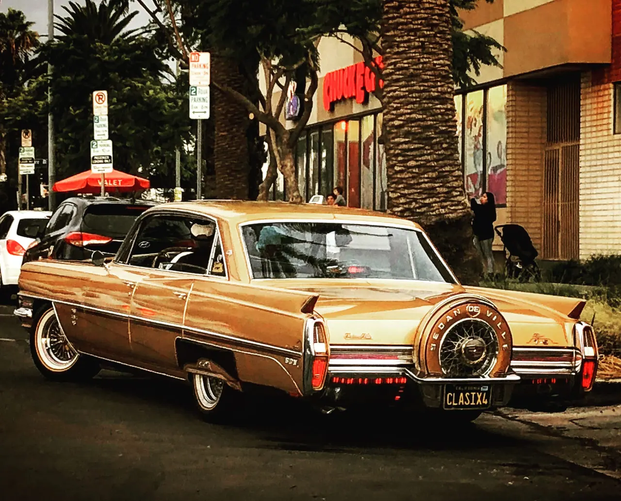 A gold classic car on an East Los Angeles street.
