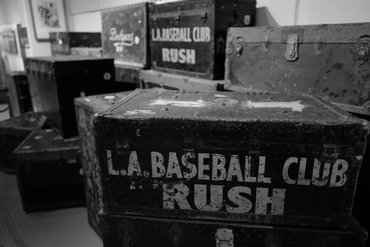 Weathered baseball-club equipment trunks stacked inside a display.