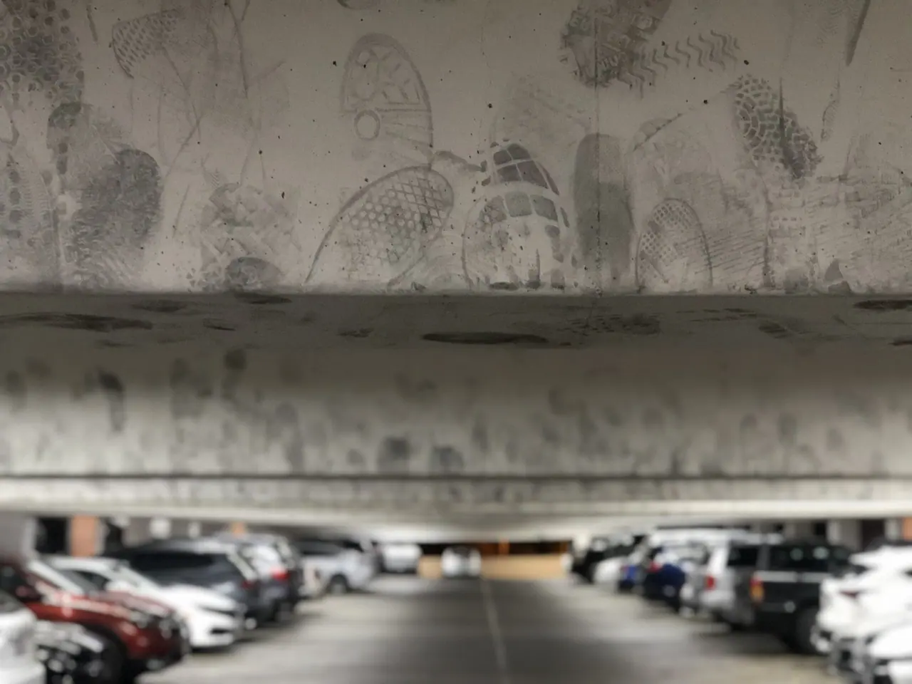 Footprints on a low beam above a parking garage.