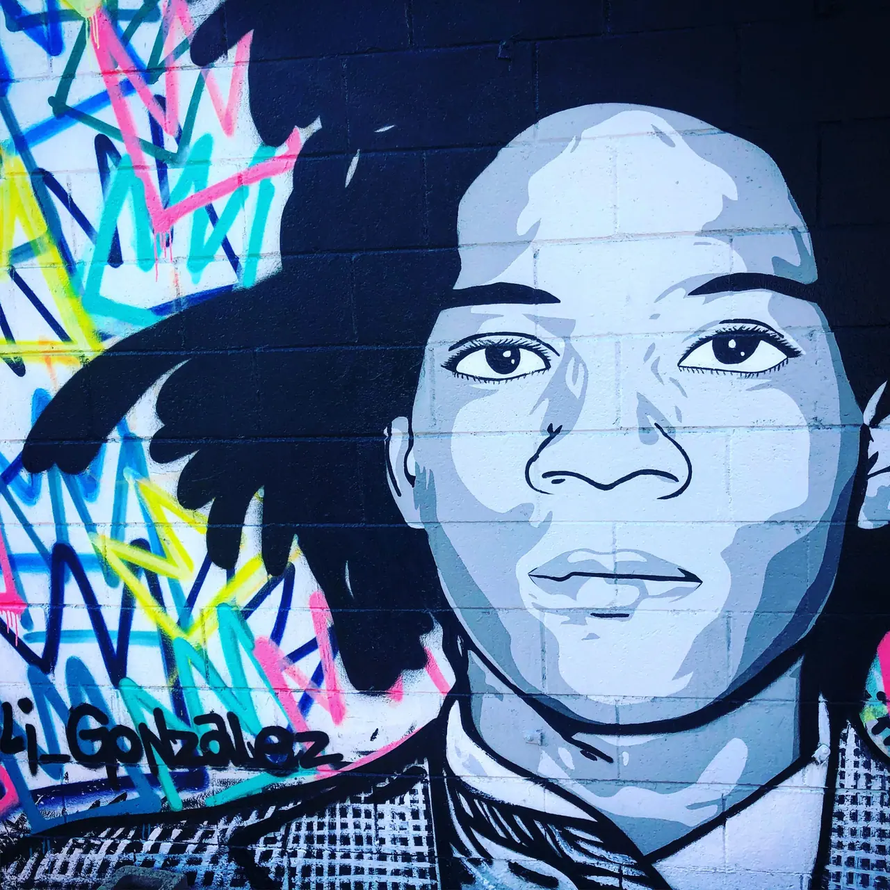 A painted portrait surrounded by colorful graffiti.