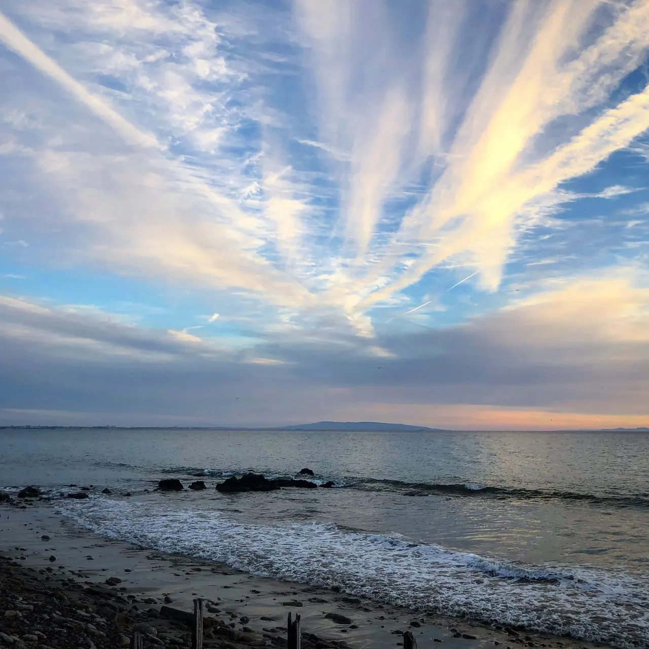 Long streaks of evening cloud above the Malibu shoreline.