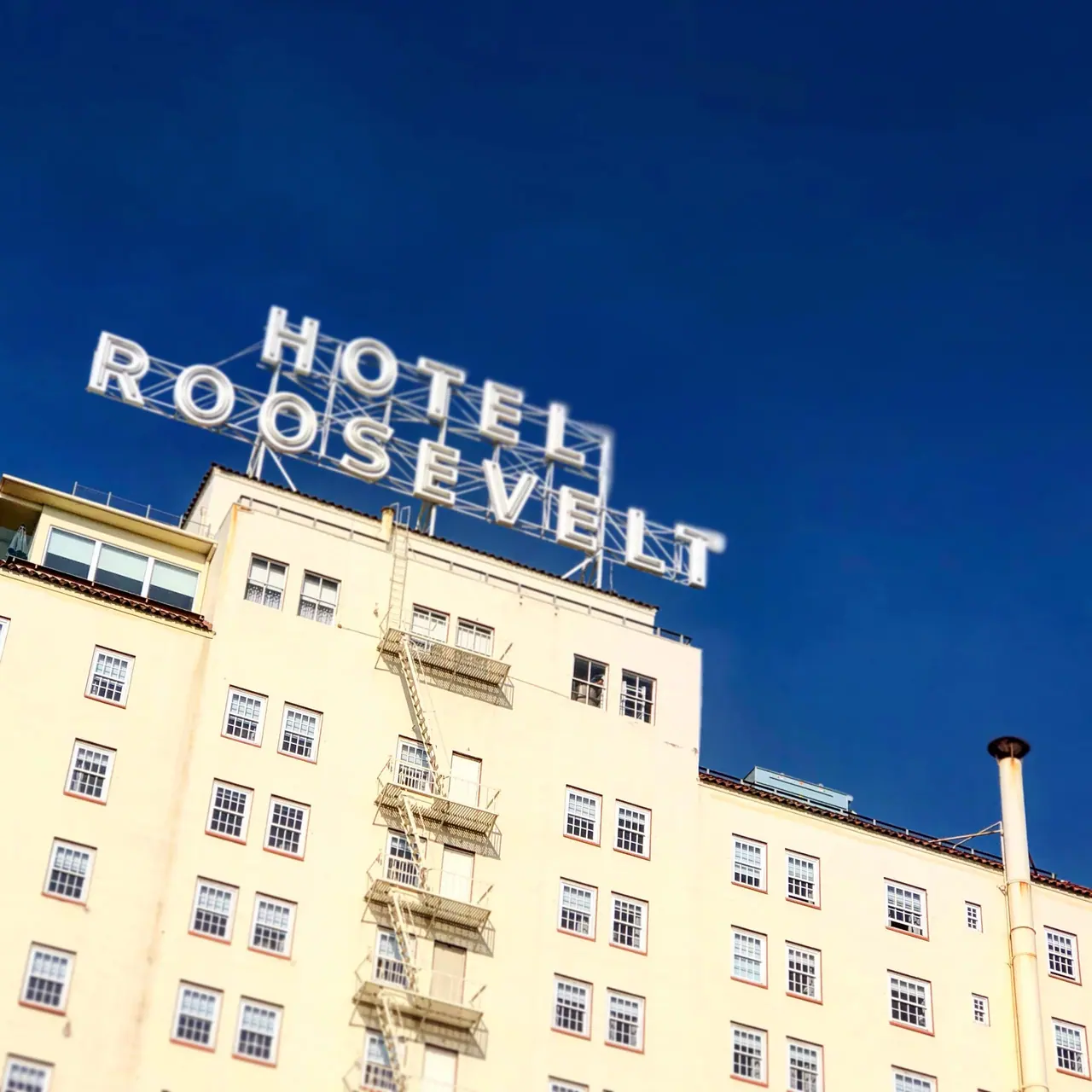 The Hotel Roosevelt rooftop sign against a deep blue sky.