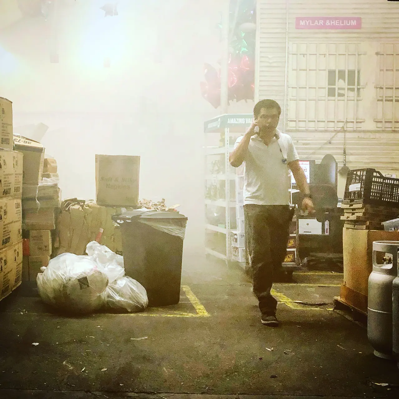 A pedestrian in hazy nighttime street light.